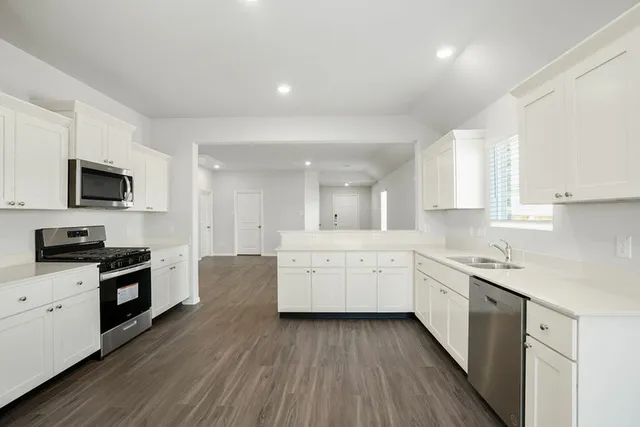 a large kitchen with a lot of counter space and wooden floor