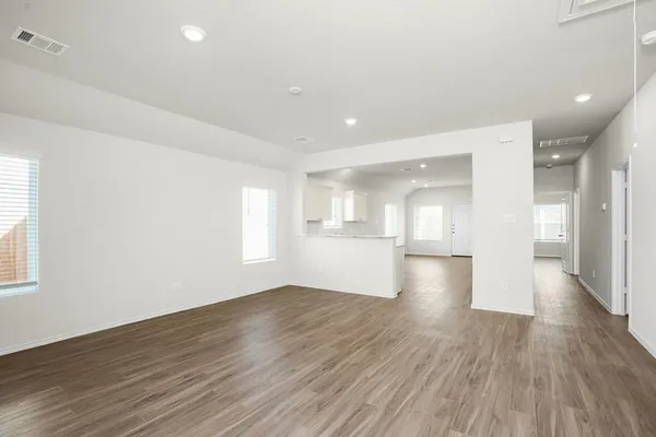 a view of empty room with wooden floor and windows