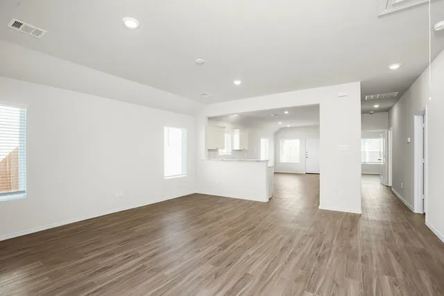 a view of empty room with wooden floor and windows