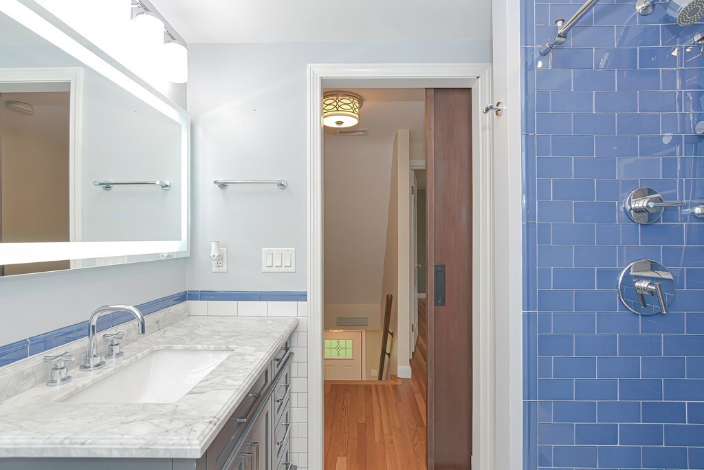 346 Highland Street Dedham, MA 02026 - Photo 28 of 42 a bathroom with a granite countertop shower a mirror and a sink
