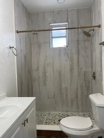 a bathroom with a sink a toilet and shower