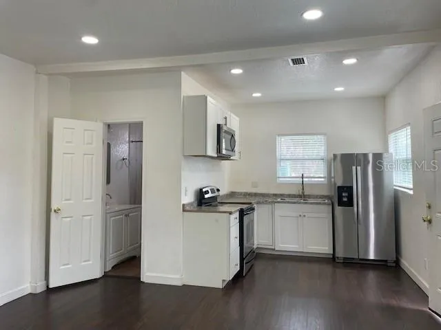 a kitchen with stainless steel appliances granite countertop a refrigerator and a stove top oven