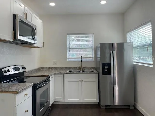 a kitchen with a sink stove and refrigerator