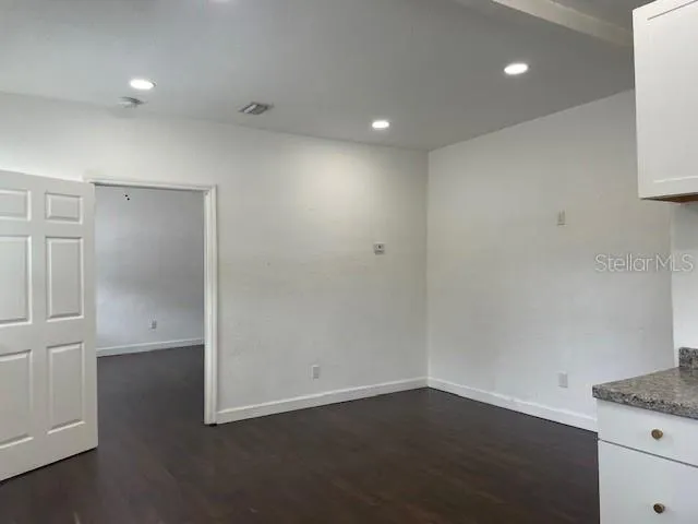 an empty room with wooden floor and cabinet
