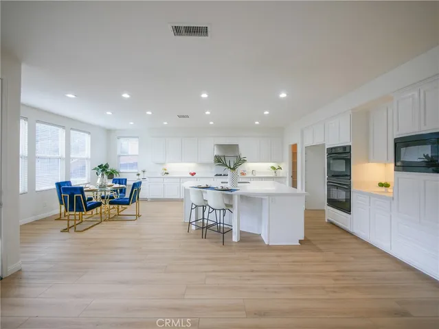 a view of kitchen and dining room with furniture wooden floor and chandelier
