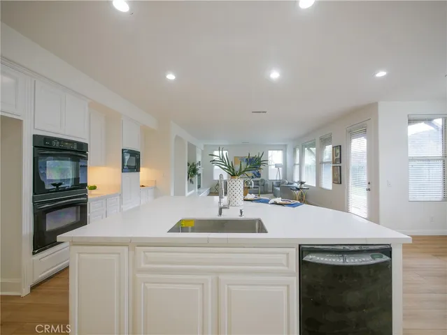 a view of a kitchen with granite countertop a sink stainless steel appliances and cabinets