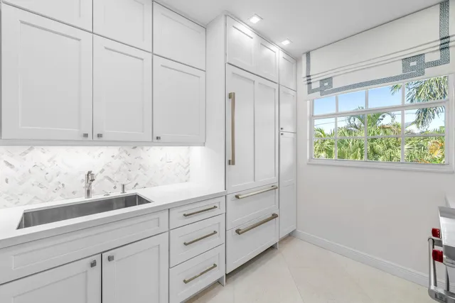 a kitchen with granite countertop white cabinets and a sink