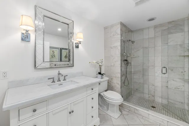 a bathroom with a sink a toilet and shower