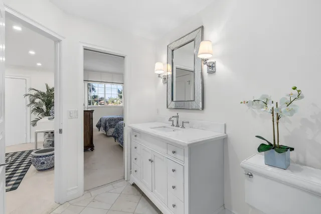 a en suite bathroom with a granite countertop sink and a mirror