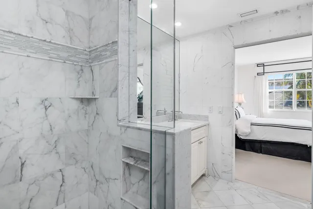 a bathroom with a granite countertop sink a mirror and shower