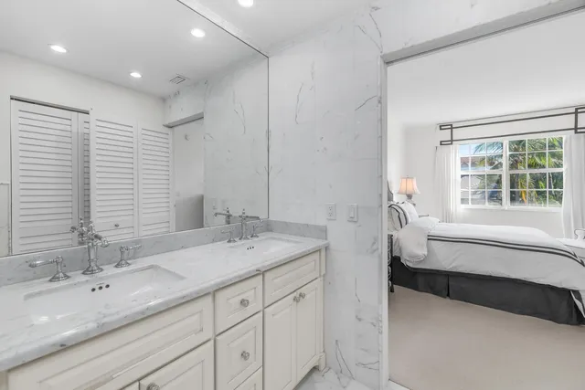 a spacious bathroom with a double vanity sink a mirror and a bathtub