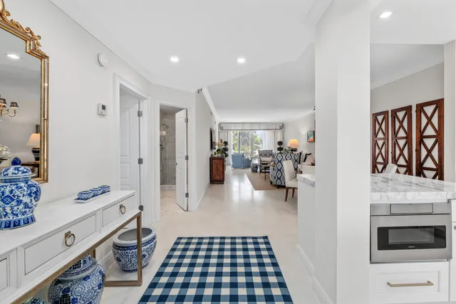 a hallway with white cabinets and black appliances