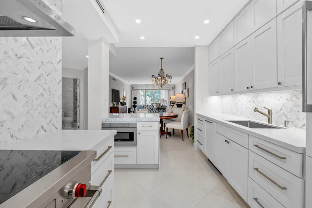 a kitchen with white cabinets and sink