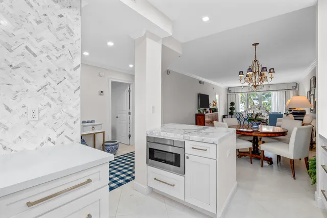 a kitchen with a white cabinets and chairs