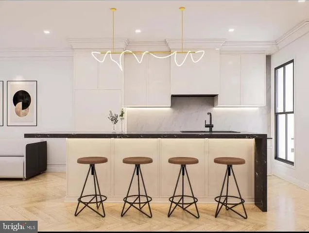a kitchen with stainless steel appliances a table chairs in it and wooden floors