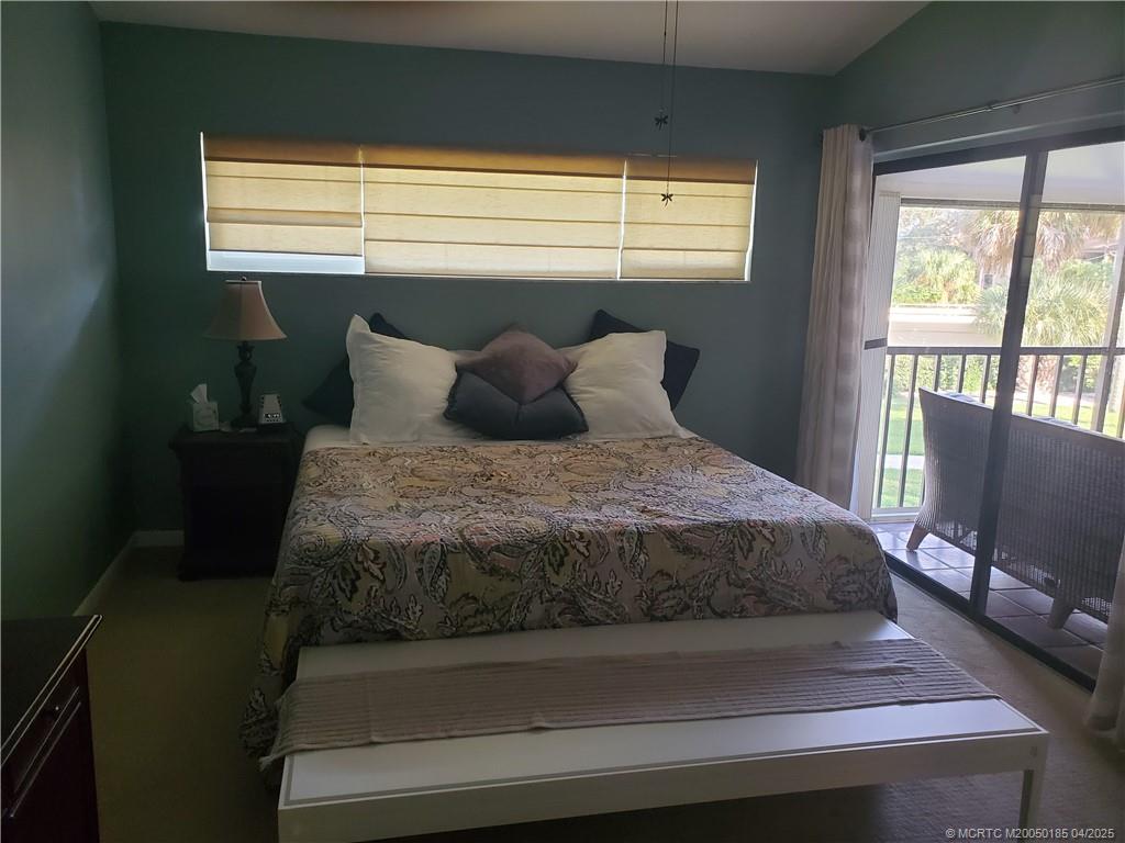 1411 Northeast 14th Court, Unit 13 Jensen Beach, FL 34957 - Photo 11 of 20 a bed sitting in a bedroom next to a window