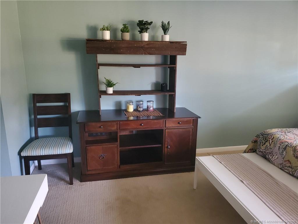 1411 Northeast 14th Court, Unit 13 Jensen Beach, FL 34957 - Photo 13 of 20 a room with a table and a fireplace