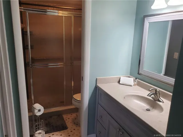 a bathroom with a sink a toilet a shower and a mirror