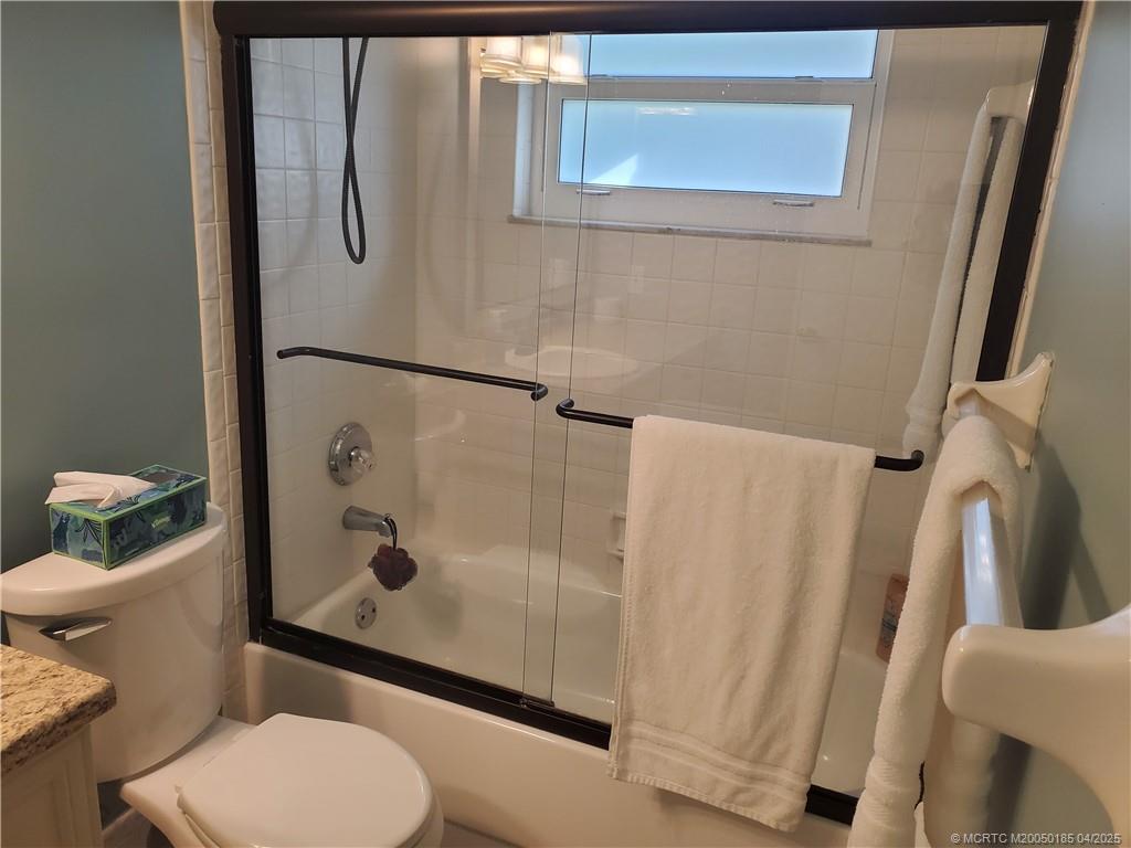 1411 Northeast 14th Court, Unit 13 Jensen Beach, FL 34957 - Photo 16 of 20 a white toilet sitting next to a bathroom sink