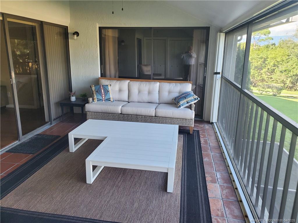 1411 Northeast 14th Court, Unit 13 Jensen Beach, FL 34957 - Photo 17 of 20 a living room with a couch and a table
