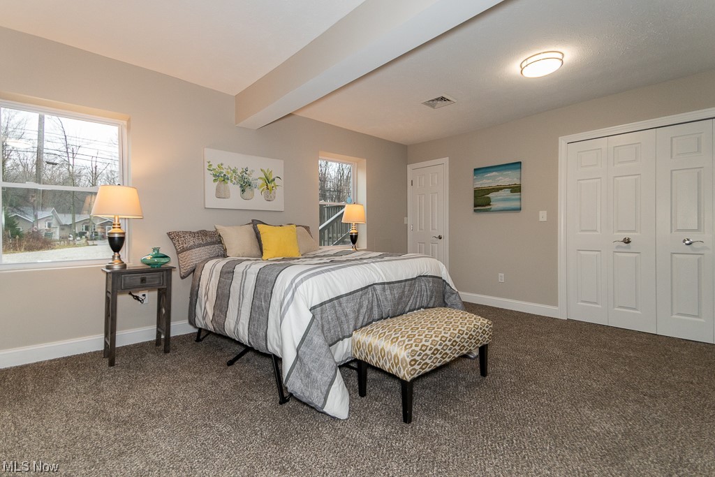 9865 Chillicothe Road Kirtland, OH 44094 - Photo 20 of 36 Bedroom with dark carpet, a closet, and beamed ceiling