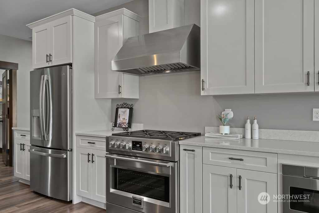 1450 Old Cedars Road Cle Elum, WA 98922 - Photo 11 of 40 a kitchen with stainless steel appliances granite countertop a stove a refrigerator and a white cabinets