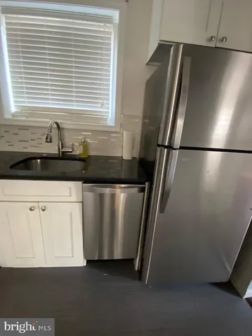 a kitchen with granite countertop a refrigerator and a sink