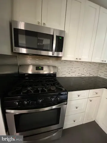 a kitchen with stainless steel appliances a stove a microwave and cabinets
