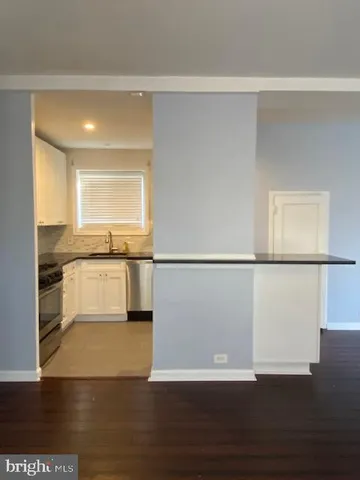 a view of a kitchen with wooden floor and a sink