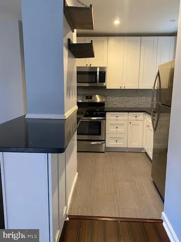 a kitchen with a refrigerator and a stove top oven