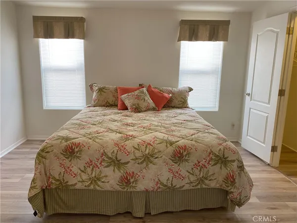 a large bed sitting in a bedroom next to a window