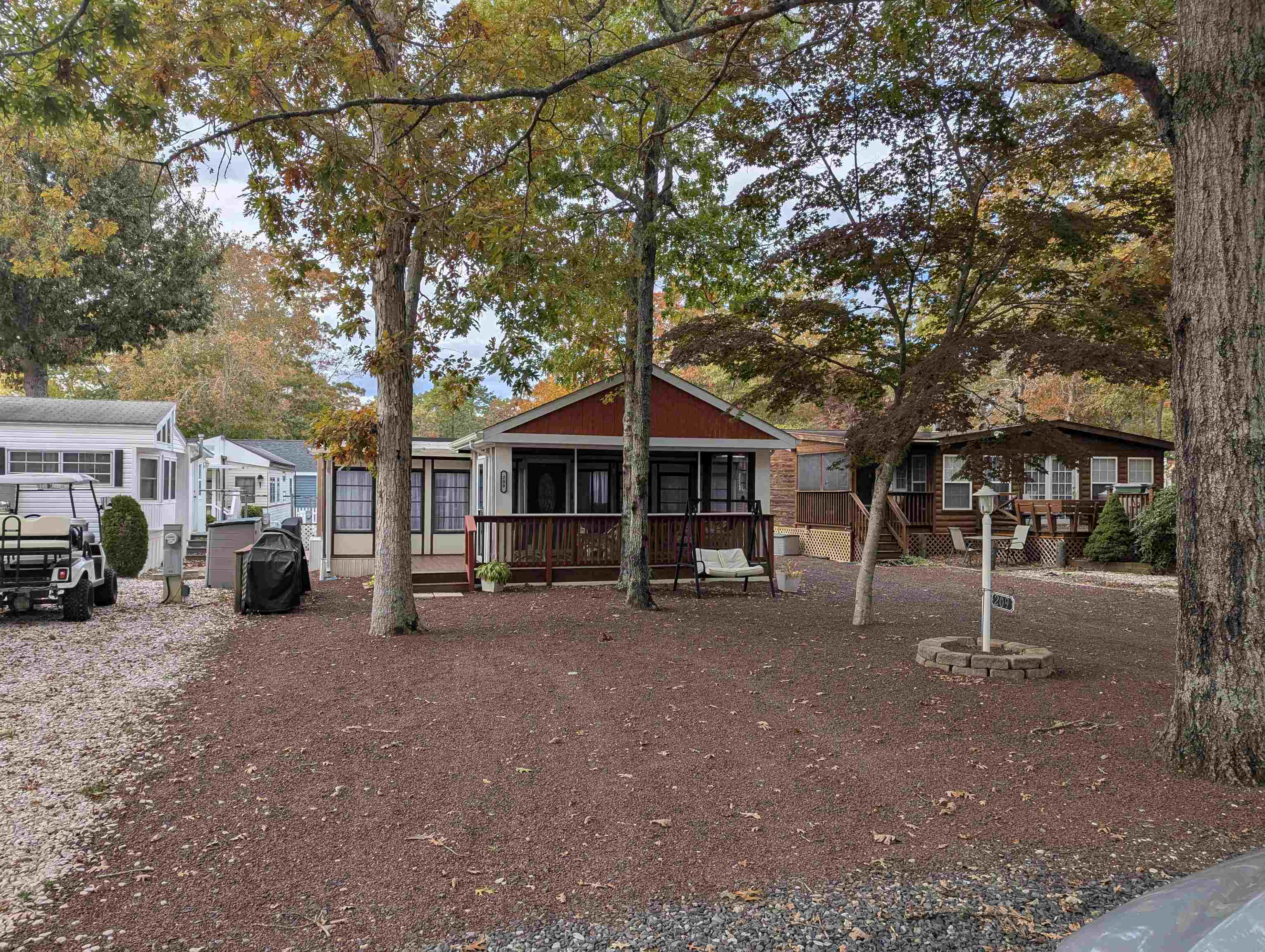a view of a house with a yard and large trees