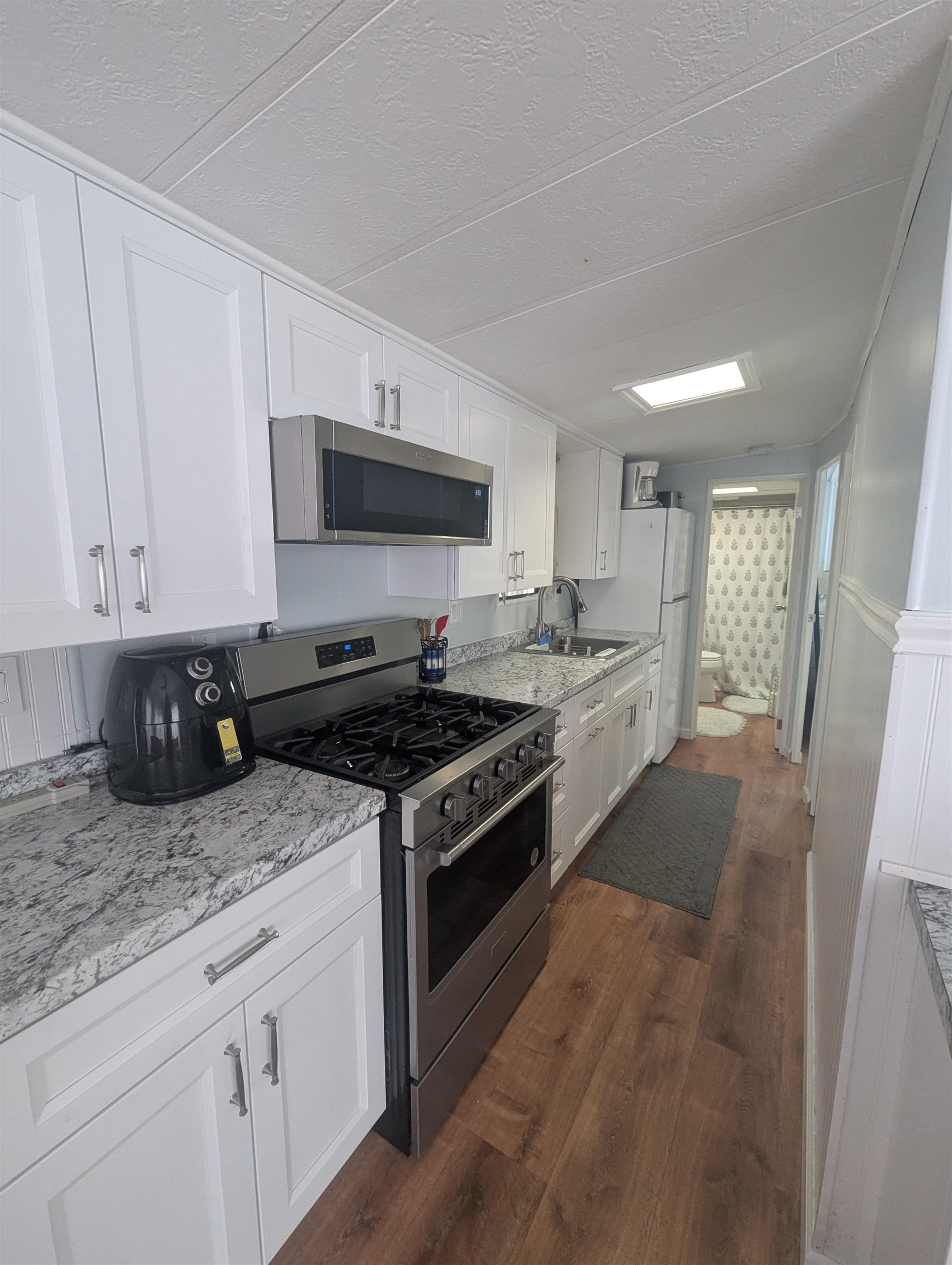 209 Horseshoe, Unit 209 Ocean View, NJ 08246 - Photo 8 of 19 a kitchen with granite countertop a sink stainless steel appliances and cabinets