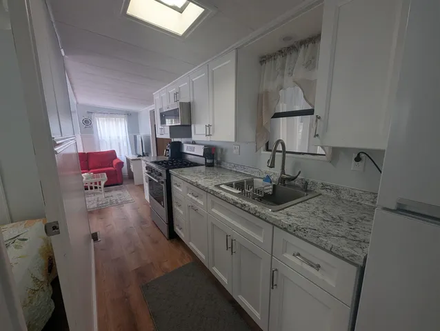 a kitchen with sink refrigerator and cabinets