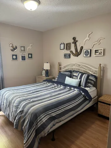 a bedroom with a bed and painting on the wall