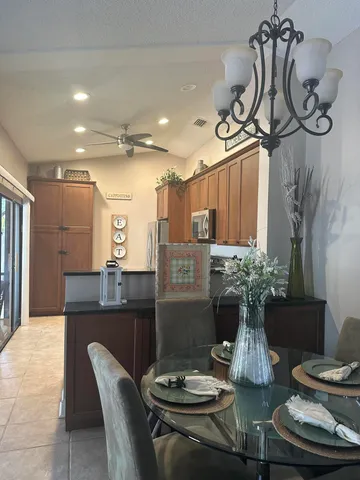 a view of a dining room with furniture a chandelier and large windows