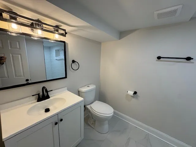 a bathroom with a sink mirror vanity and toilet