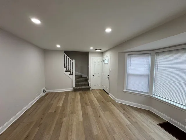 a view of empty room with wooden floor