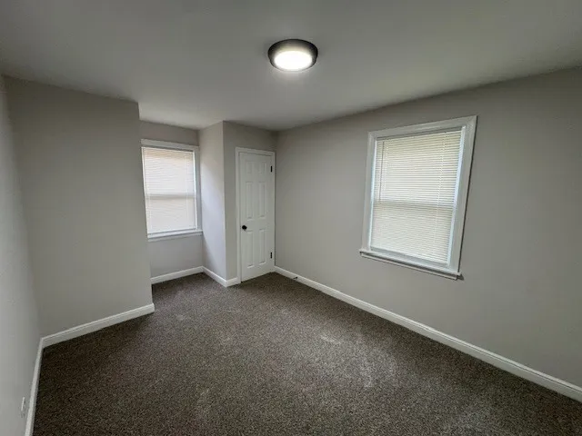 an empty room with windows and closet