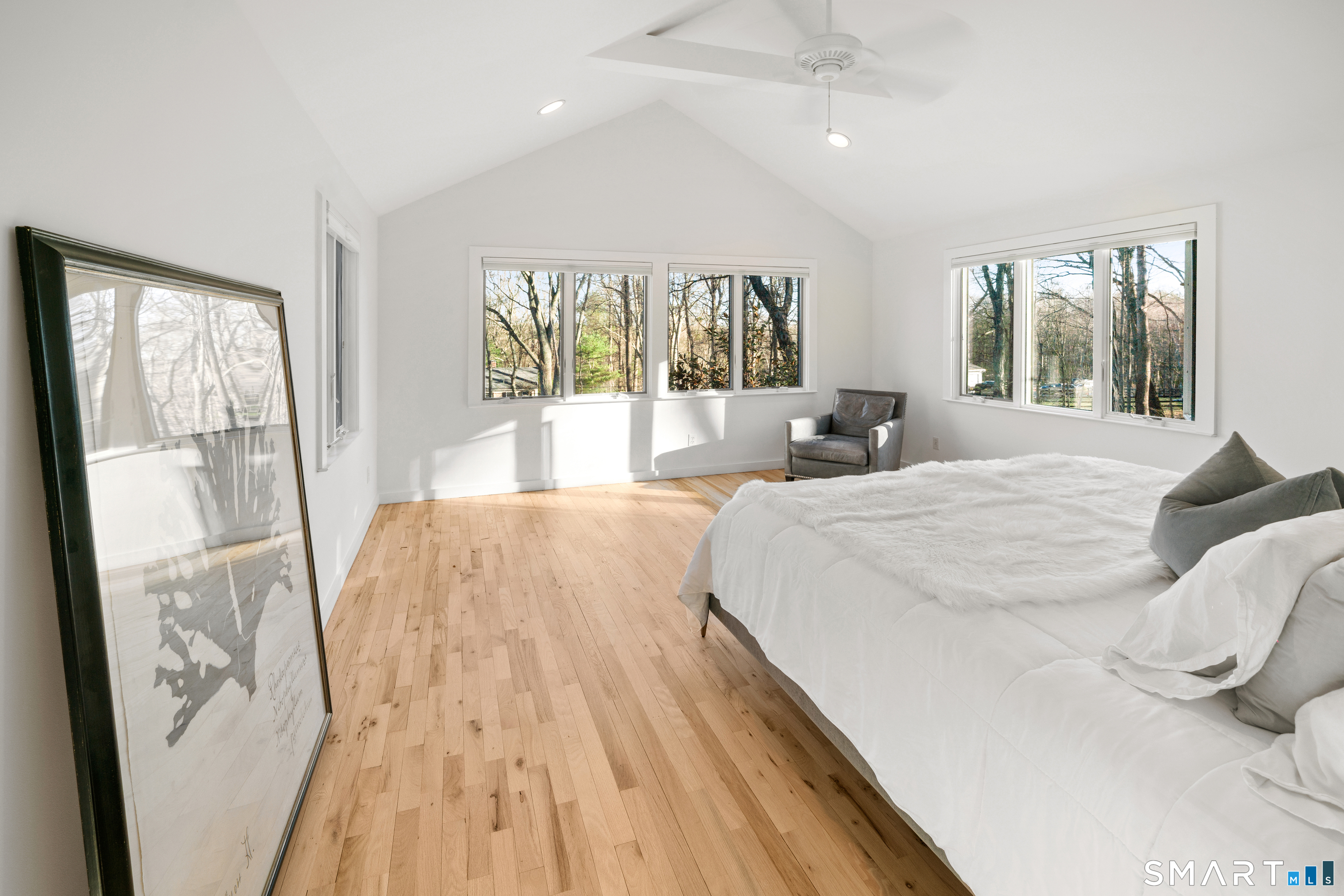 23 Norton Road Easton, CT 06612 - Photo 22 of 40 The primary suite is filled with natural light from expansive windows, offering a serene, tucked away feel within its natural setting.