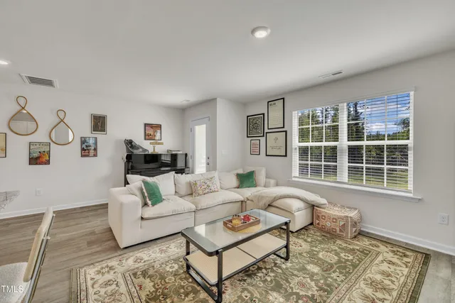 a living room with furniture a rug and a window