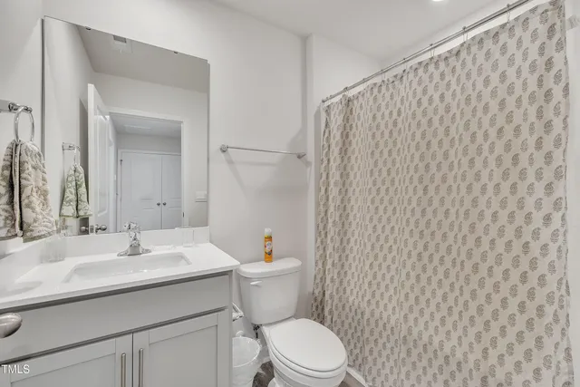 a bathroom with a sink a toilet and shower curtain
