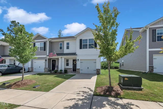 a front view of a house with a yard and trees