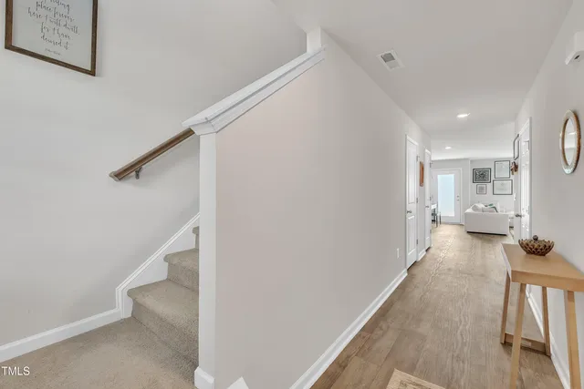 a view of a hallway with wooden floor and staircase