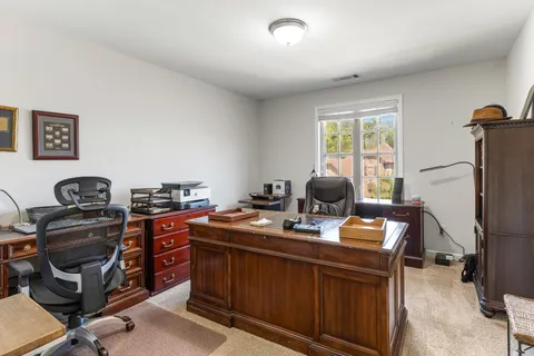 a view of a workspace with furniture and a window