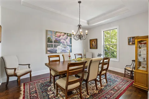 a view of a dining room with furniture a chandelier and wooden floor