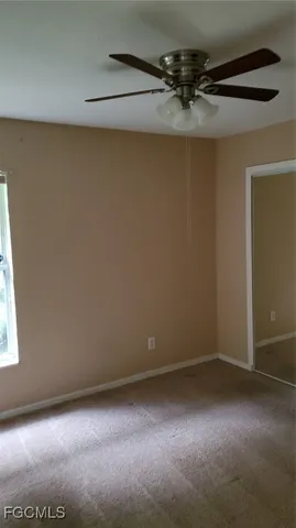 a view of a room with a ceiling fan and a window