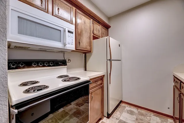 a kitchen with stainless steel appliances granite countertop a refrigerator and a stove