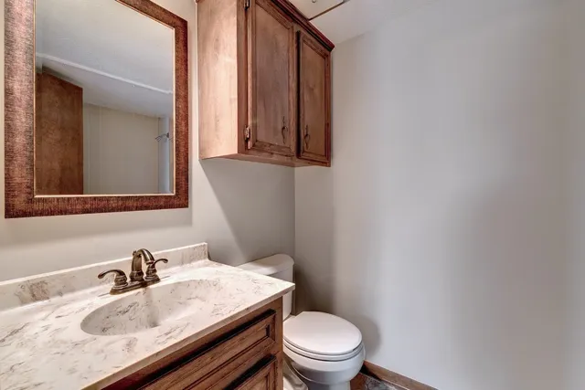 a bathroom with a sink toilet and mirror
