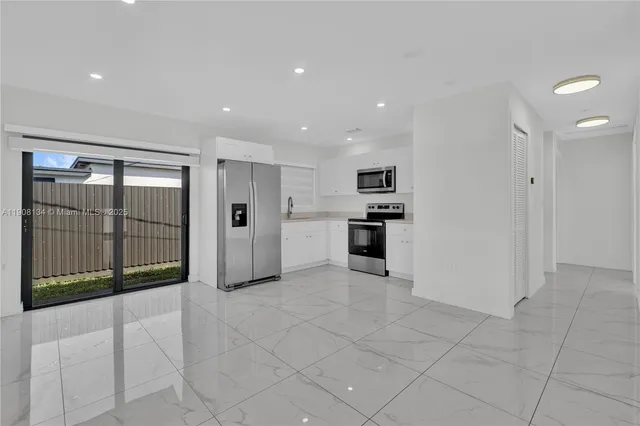 a view of a kitchen with refrigerator and windows